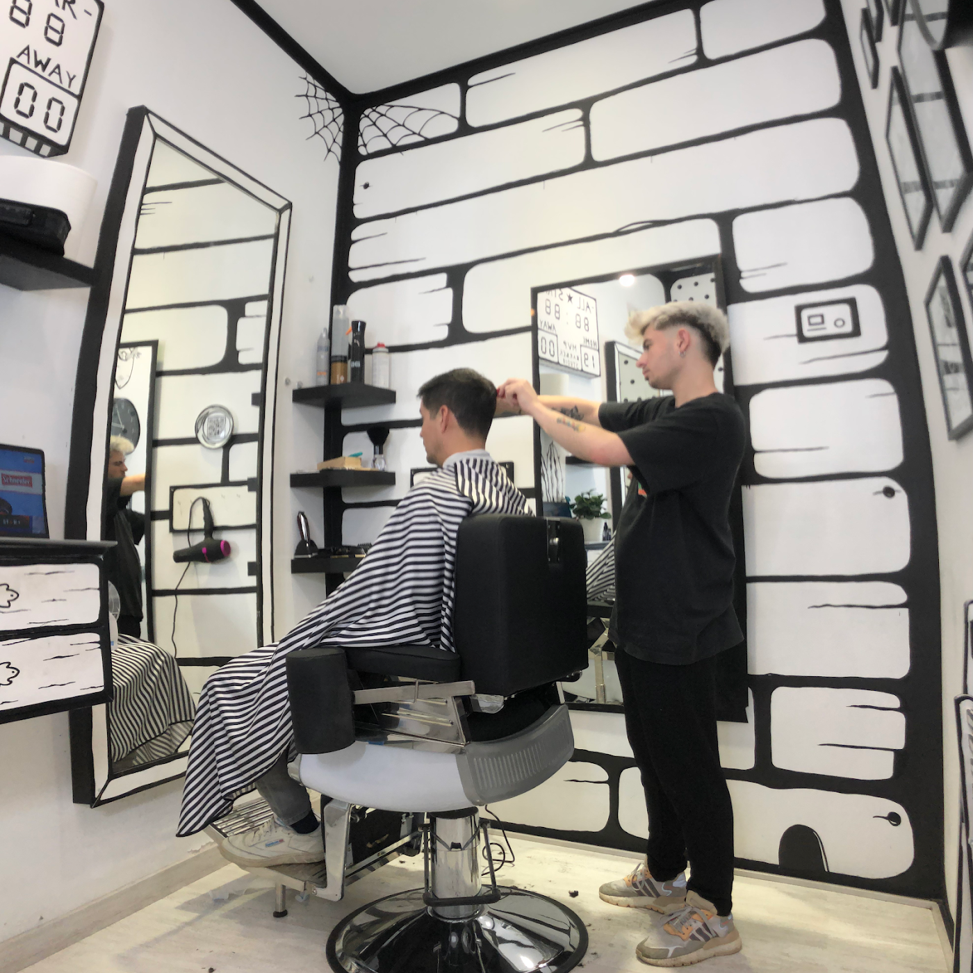 Barbero trabajando entre los muros pintados